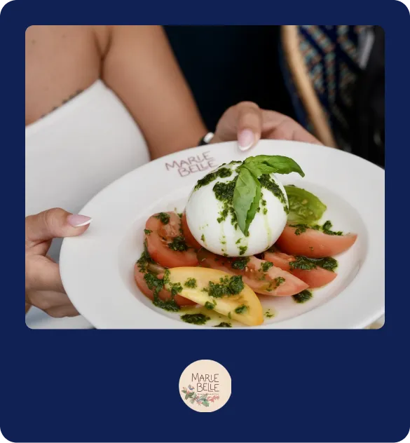 Salade burrata et tomates servie sur assiette blanche