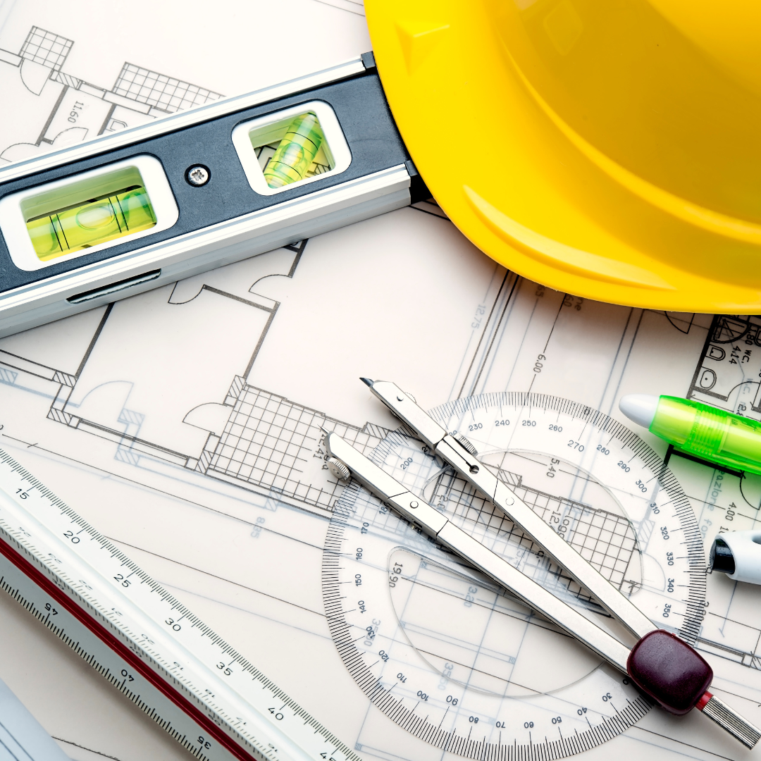 Confident man with beard in black suit and tie, standing with arms crossed against white background.