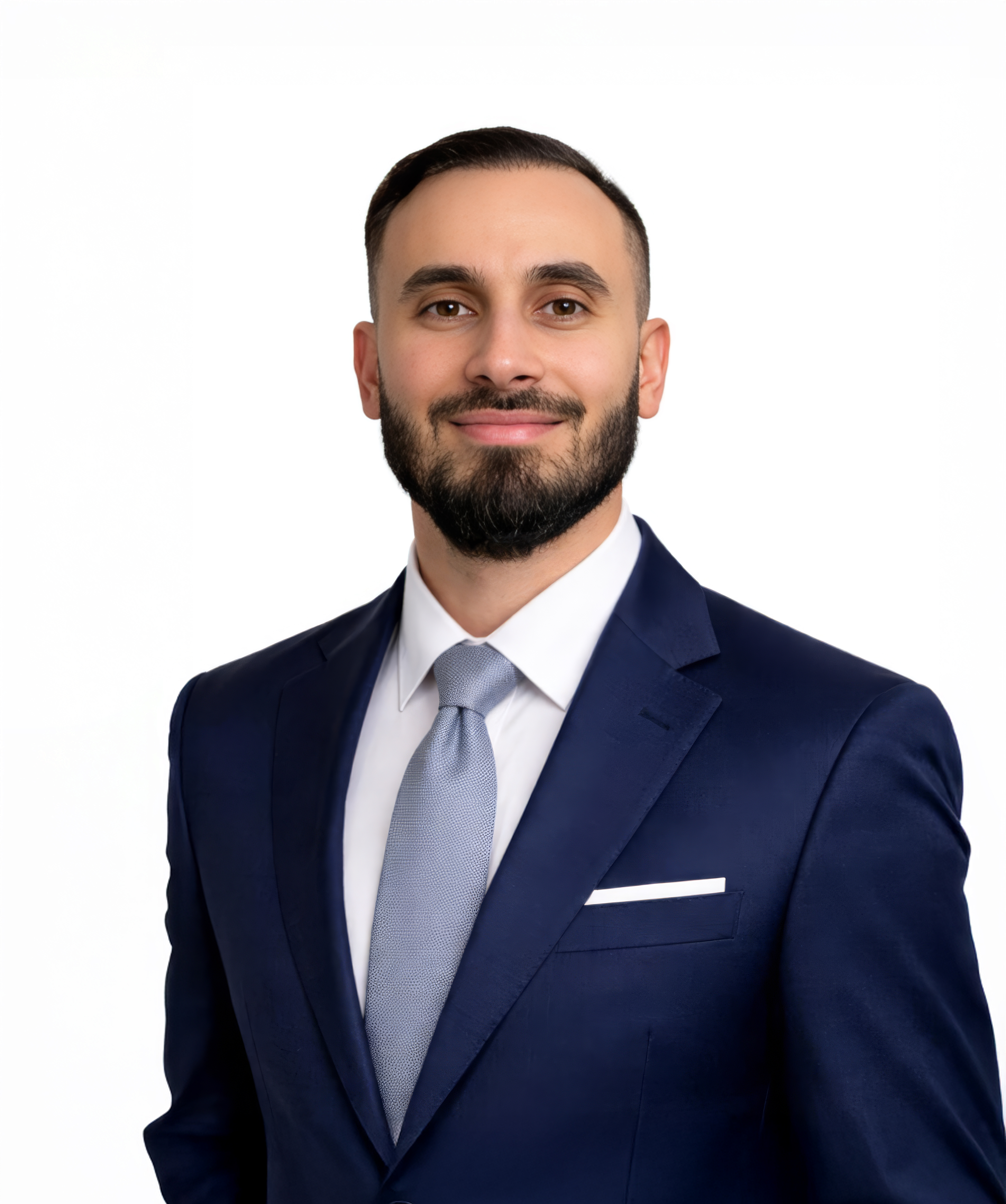 Smiling man wearing a navy blue suit with a white shirt and light blue tie against a white background.