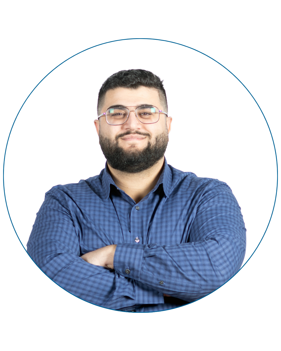 Smiling man with beard and glasses wearing a blue checkered shirt with arms crossed.