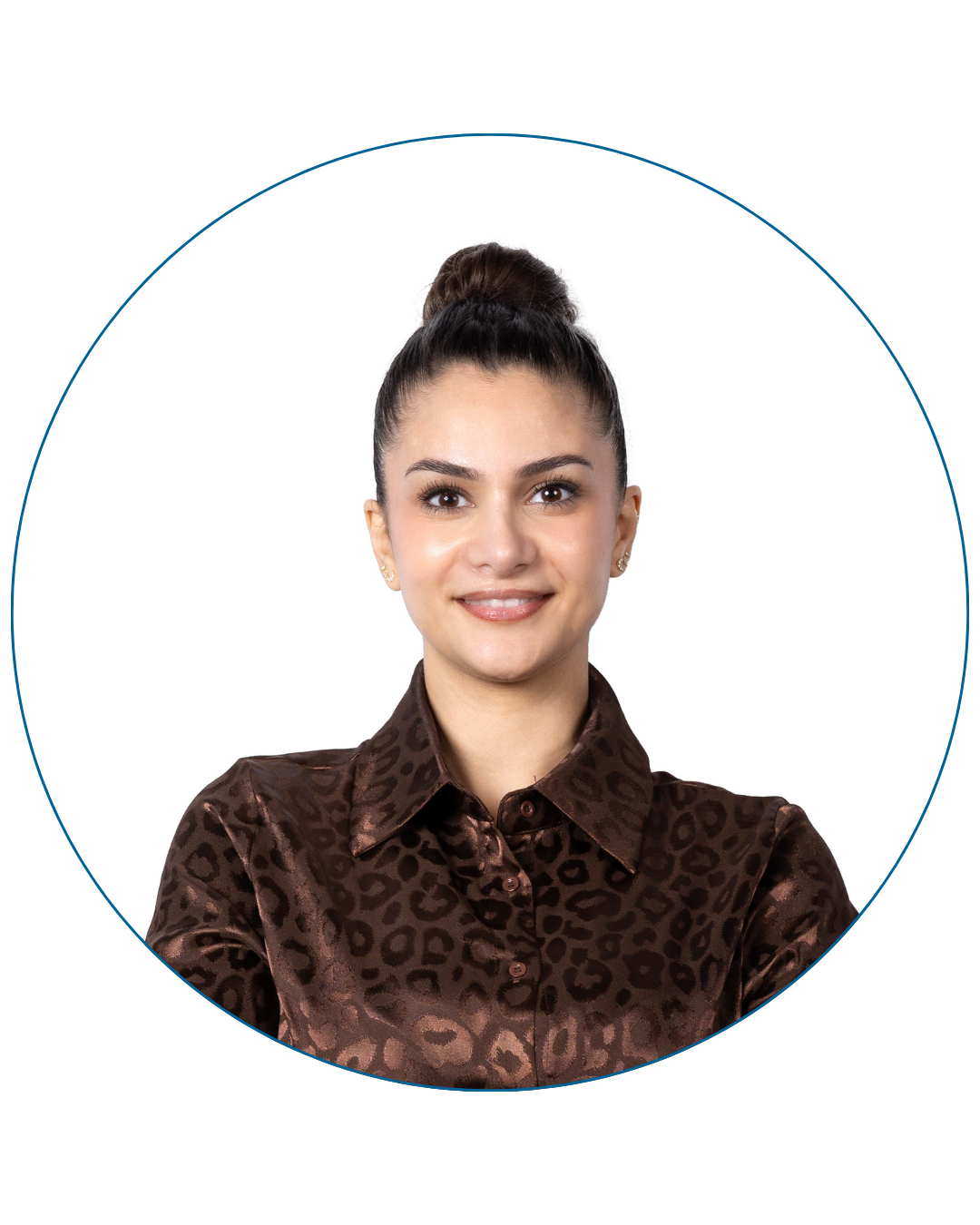 Smiling woman with dark hair in a bun wearing a brown patterned satin blouse.
