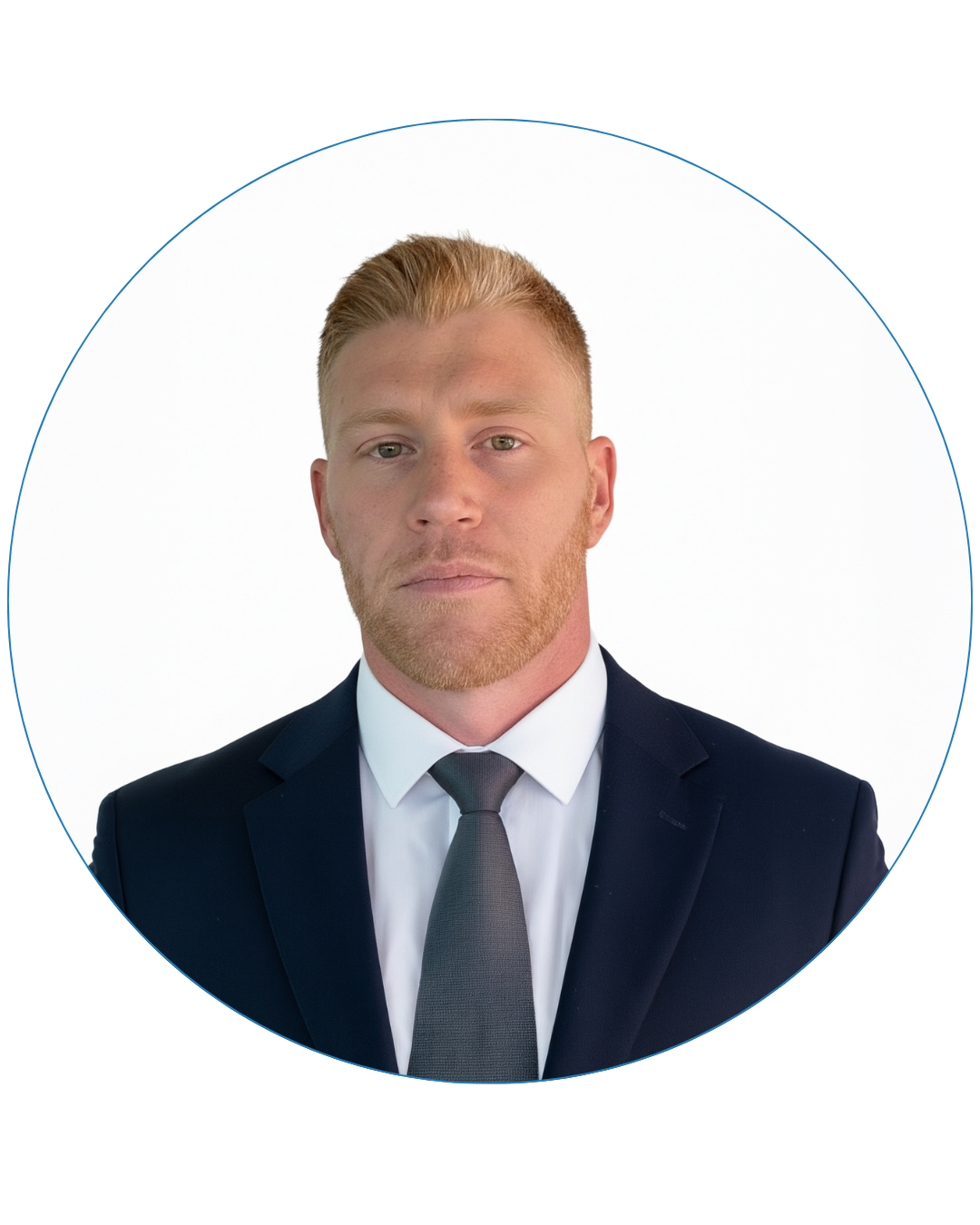 Serious young man with short blond hair and beard wearing a dark suit, white shirt, and grey tie against a white background.