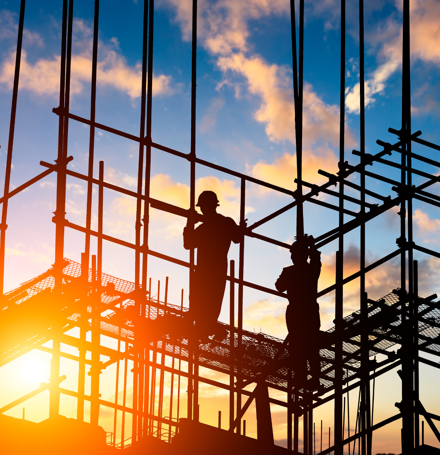Smiling construction worker wearing a green hard hat and orange safety vest holding a tablet at a construction site with a crane and building covered in green netting.