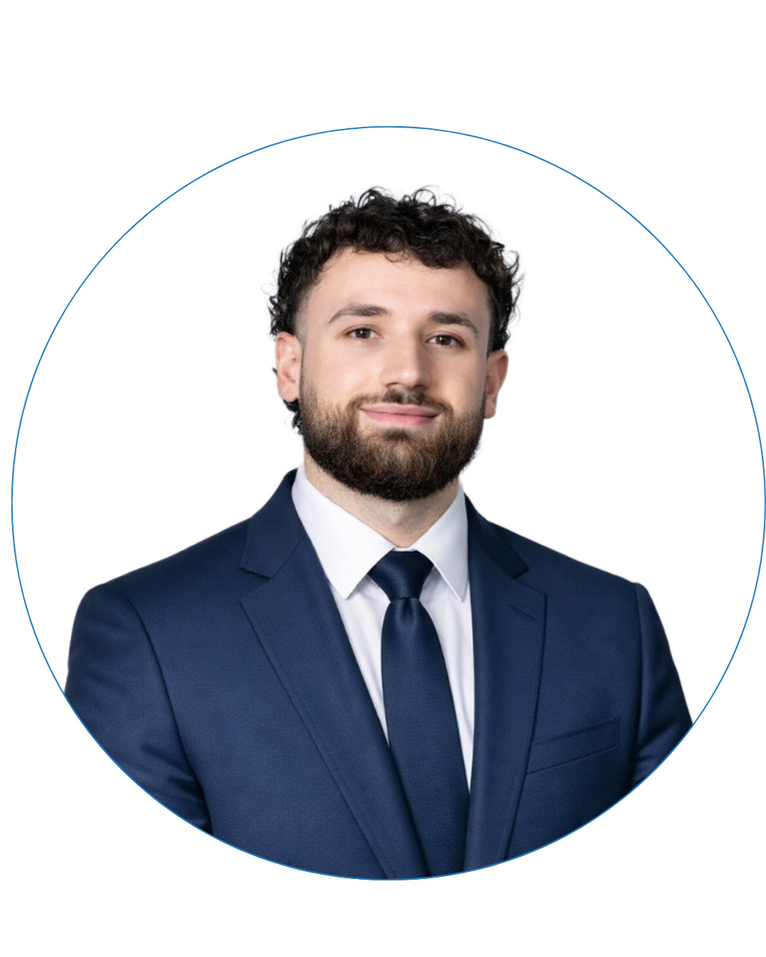 Portrait of a man with curly hair and beard wearing a navy suit, white shirt, and navy tie, smiling slightly.