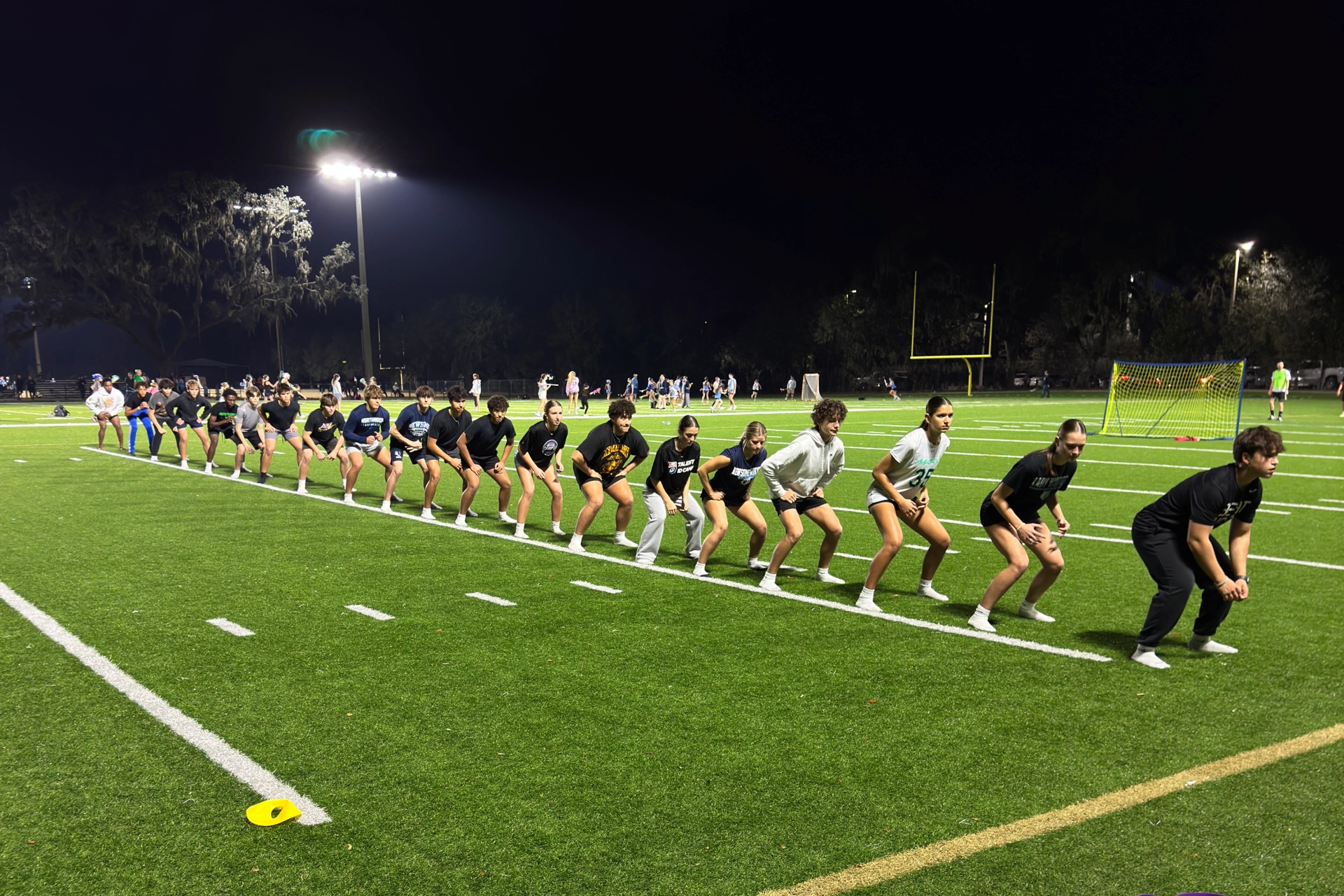 A line of people standing on a football field at Mega Athletics in Fish Hawk, FL.