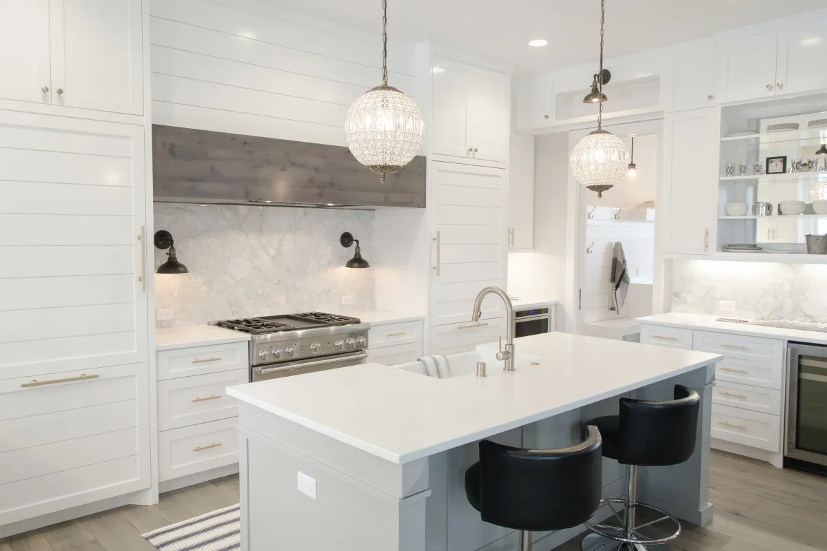 Clean and bright kitchen with round pendant lights above island