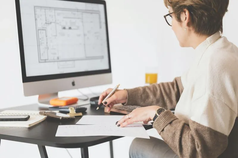 Interior designer sitting a table working on CAD drawing