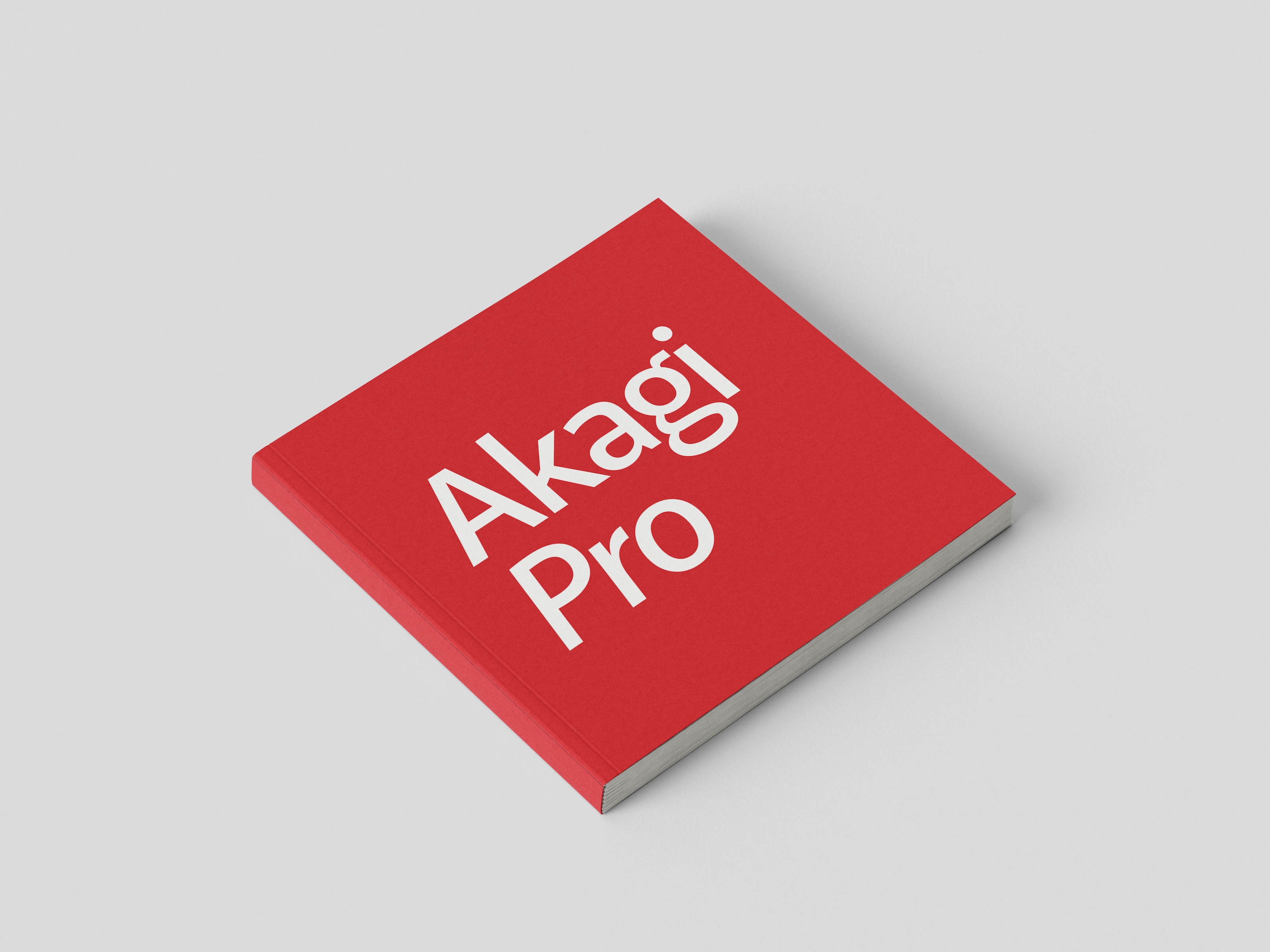 Red square book with the white text 'Akagi Pro' on the cover, placed on a light gray surface.