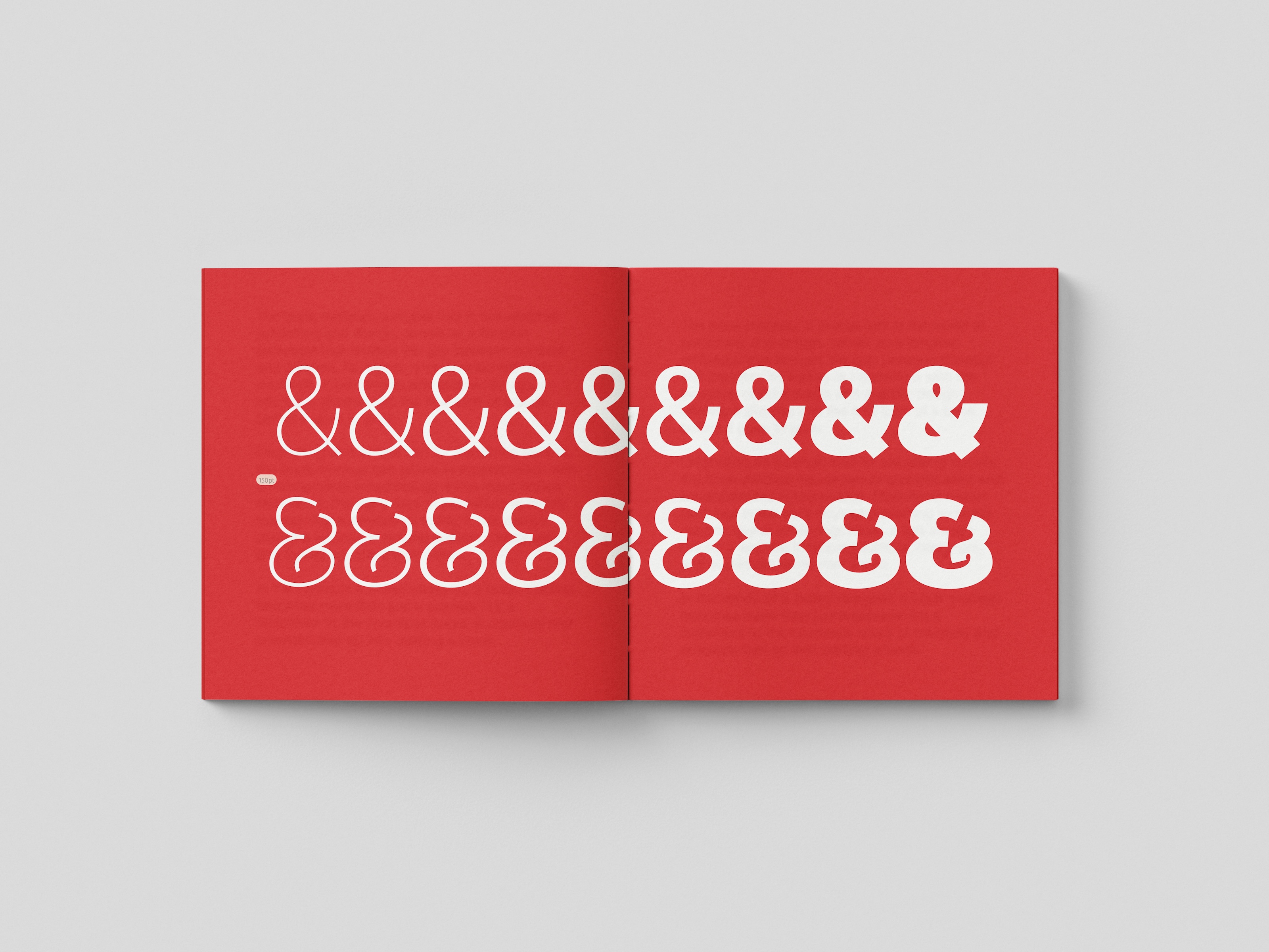 Open book with red pages displaying various ampersand (&) symbols in different fonts and sizes.