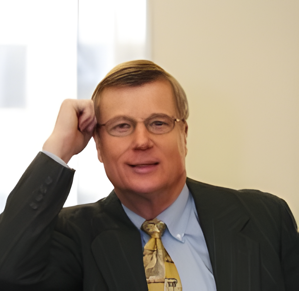 Headshot of David Walker, wearing glasses and yellow tie. short brown hair.