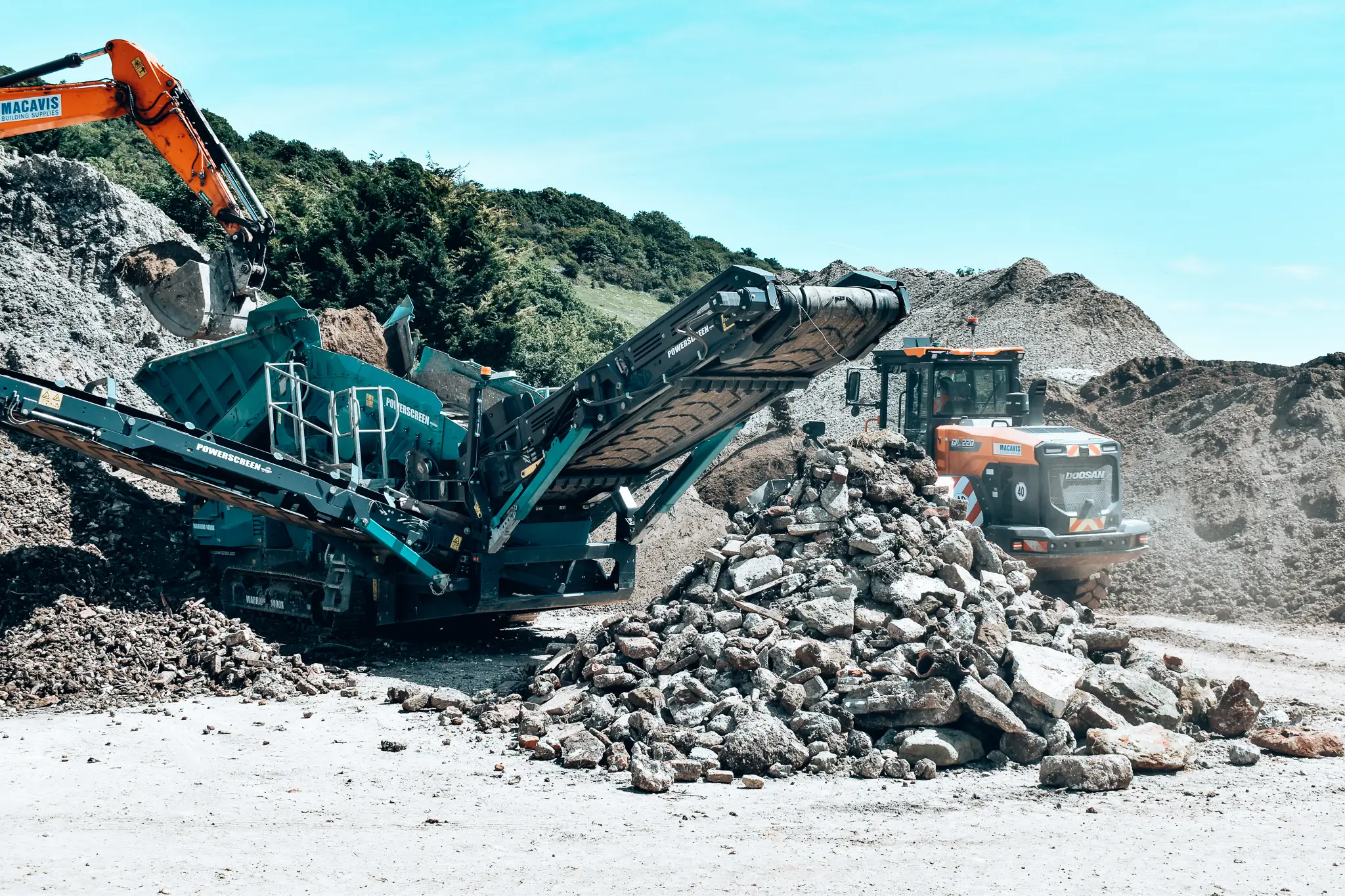 Industrial rock crusher processing stone at quarry with heavy machinery