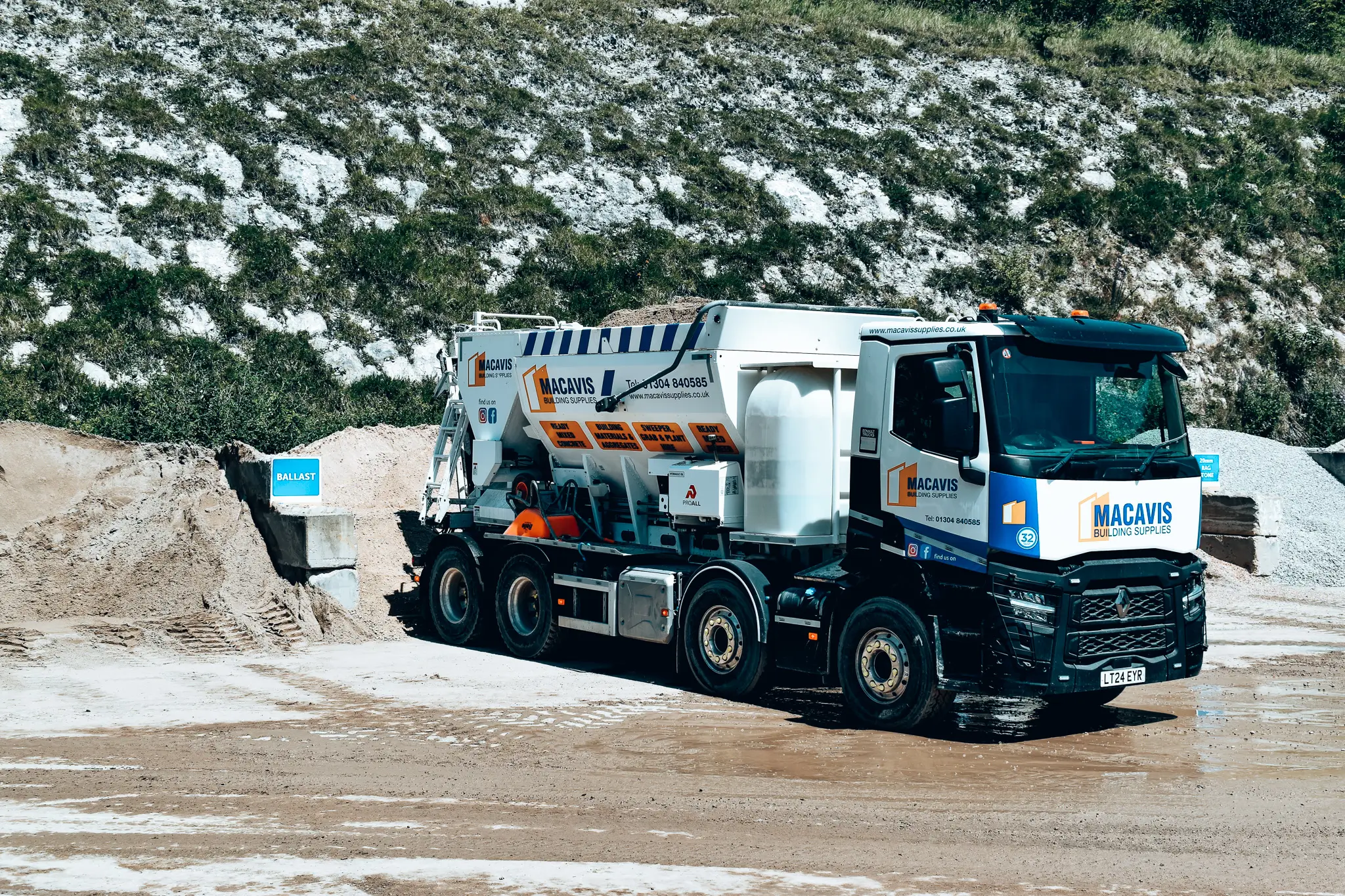 Macavis building supplies truck parked at construction site with ballast
