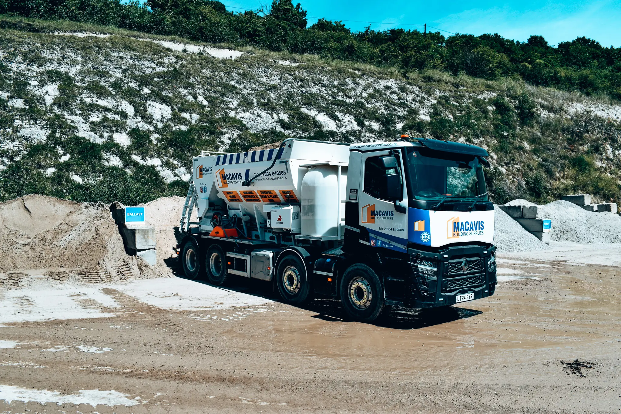 Macavis delivery truck parked at quarry with rocky background