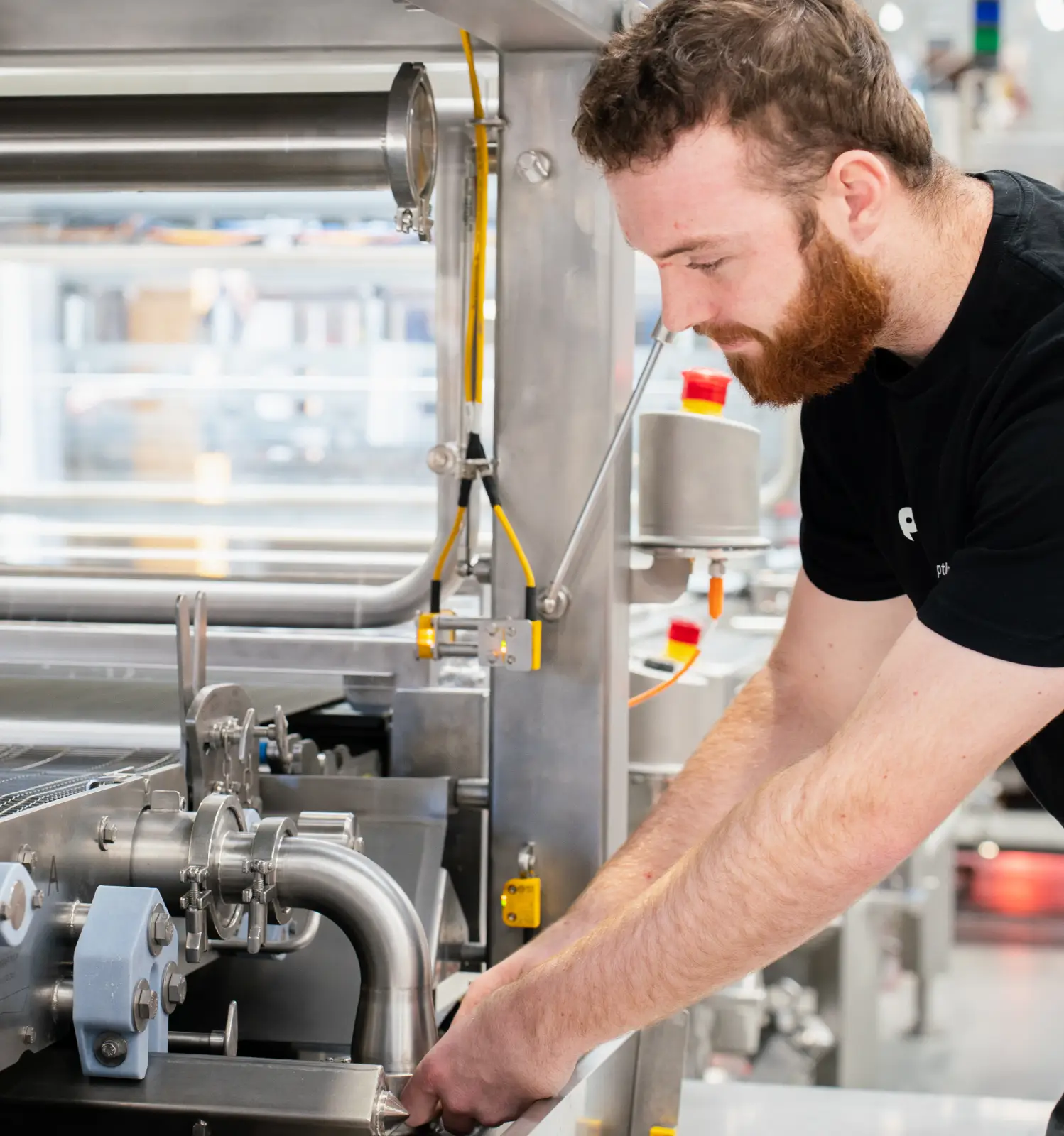 A man in a black shirt is working on a machine.