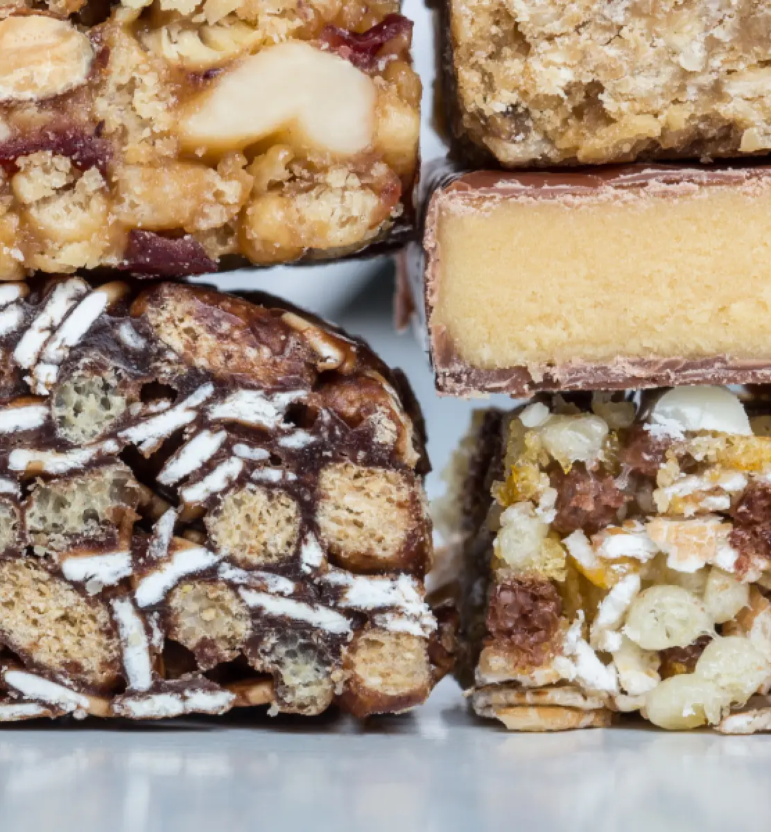 A close up of a variety of desserts including a brownie, a cake, and a bar.