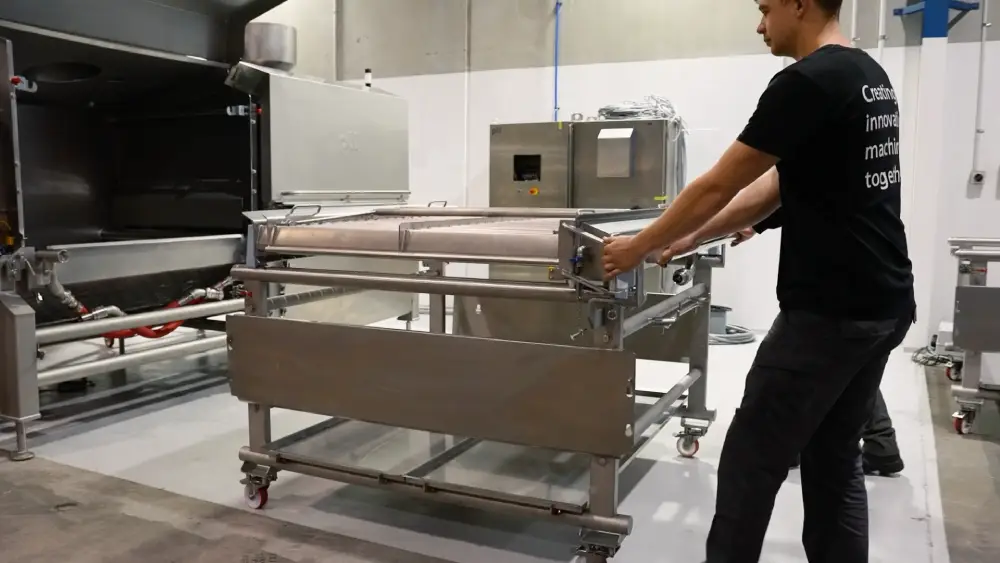 A man is opening a metal box in a factory.