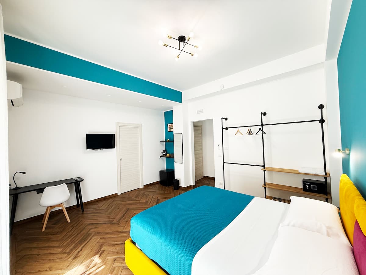 Letto matrimoniale con pareti azzurre e arredamento moderno