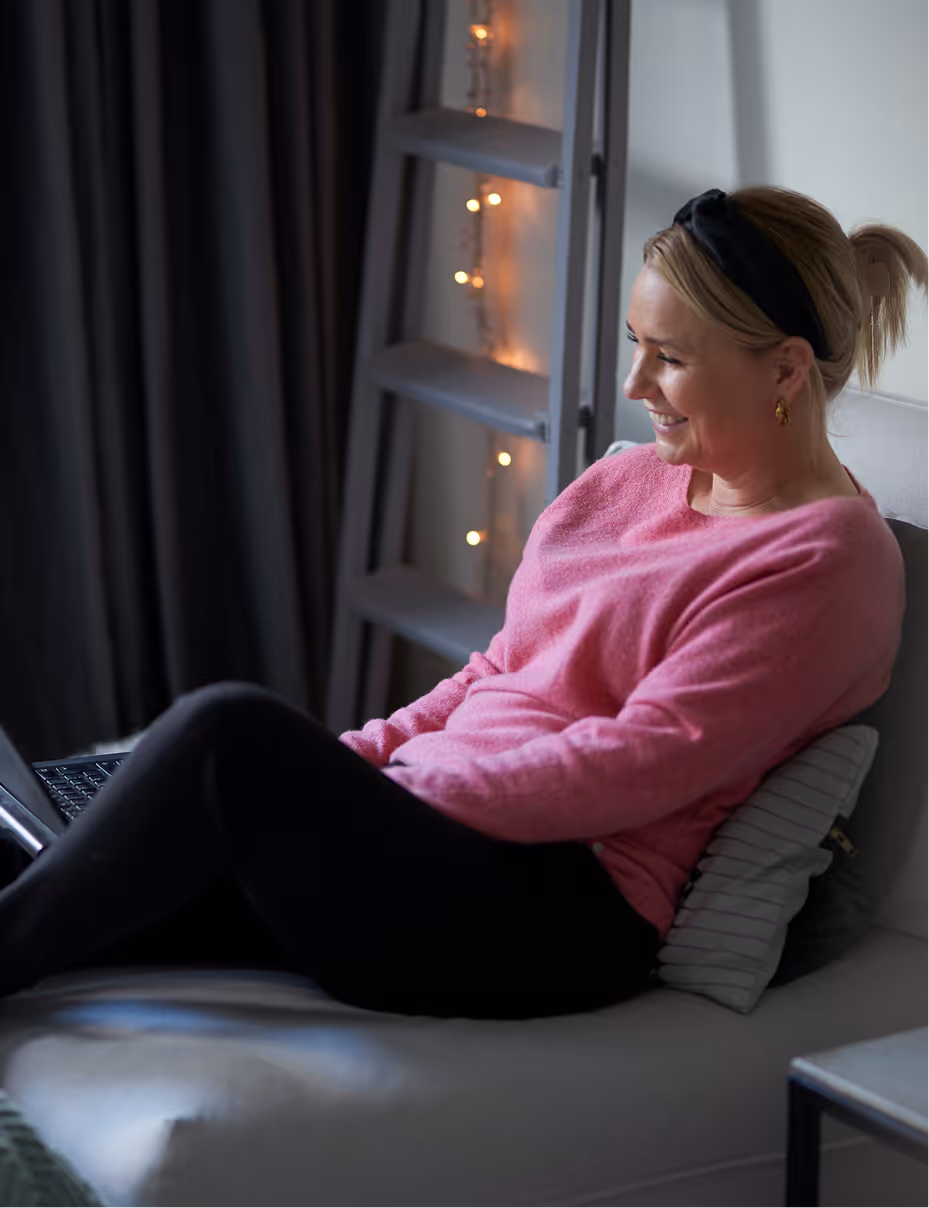 Frau liegt fröhlich auf der Couch