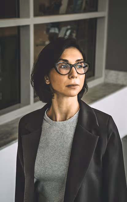 Frau mit schwarzen Haaren und Brille