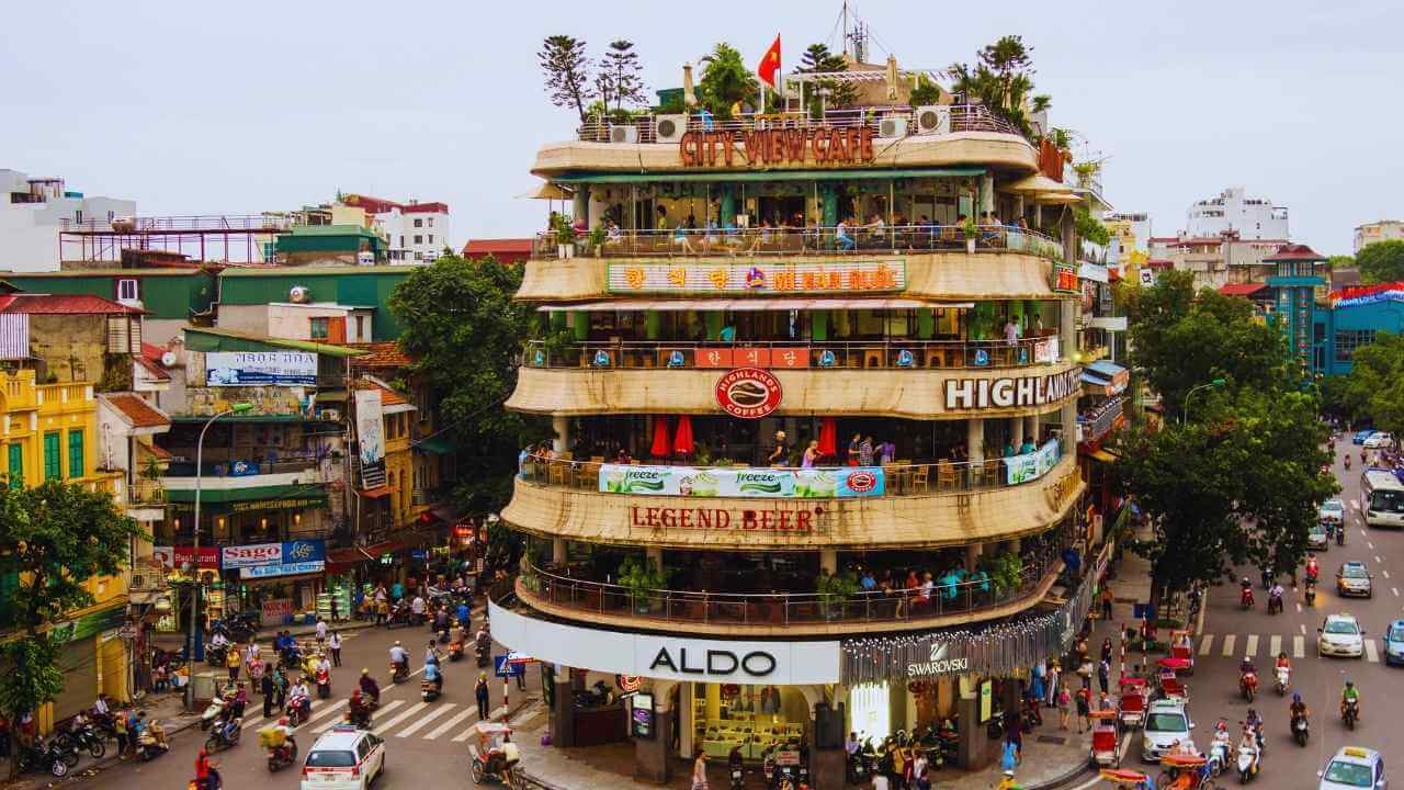 An iconic yellow building above a bustling street in Hanoi's Old Quarter.