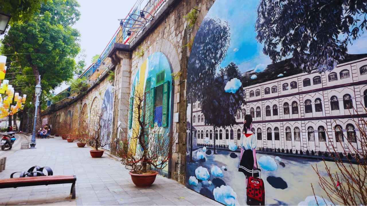 Colorful Hanoi street art murals on the stone arches of Phung Hung Mural Street.