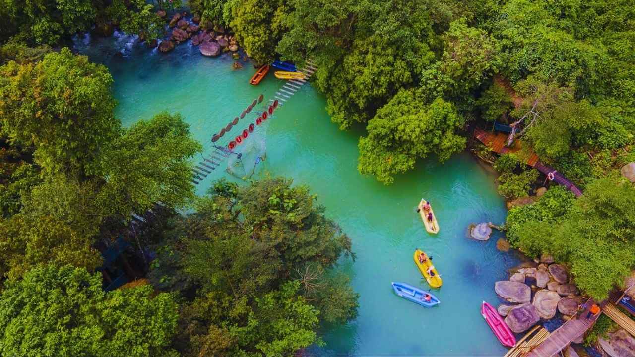 Tourists kayaking on the stunning turquoise water of Mooc Spring in Quang Binh.