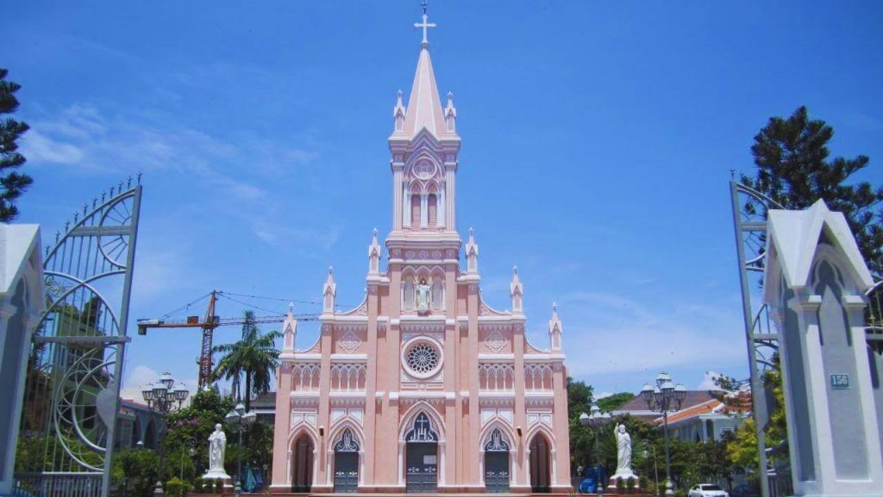 The famous pink facade of Da Nang Cathedral under a bright blue sky in Vietnam.