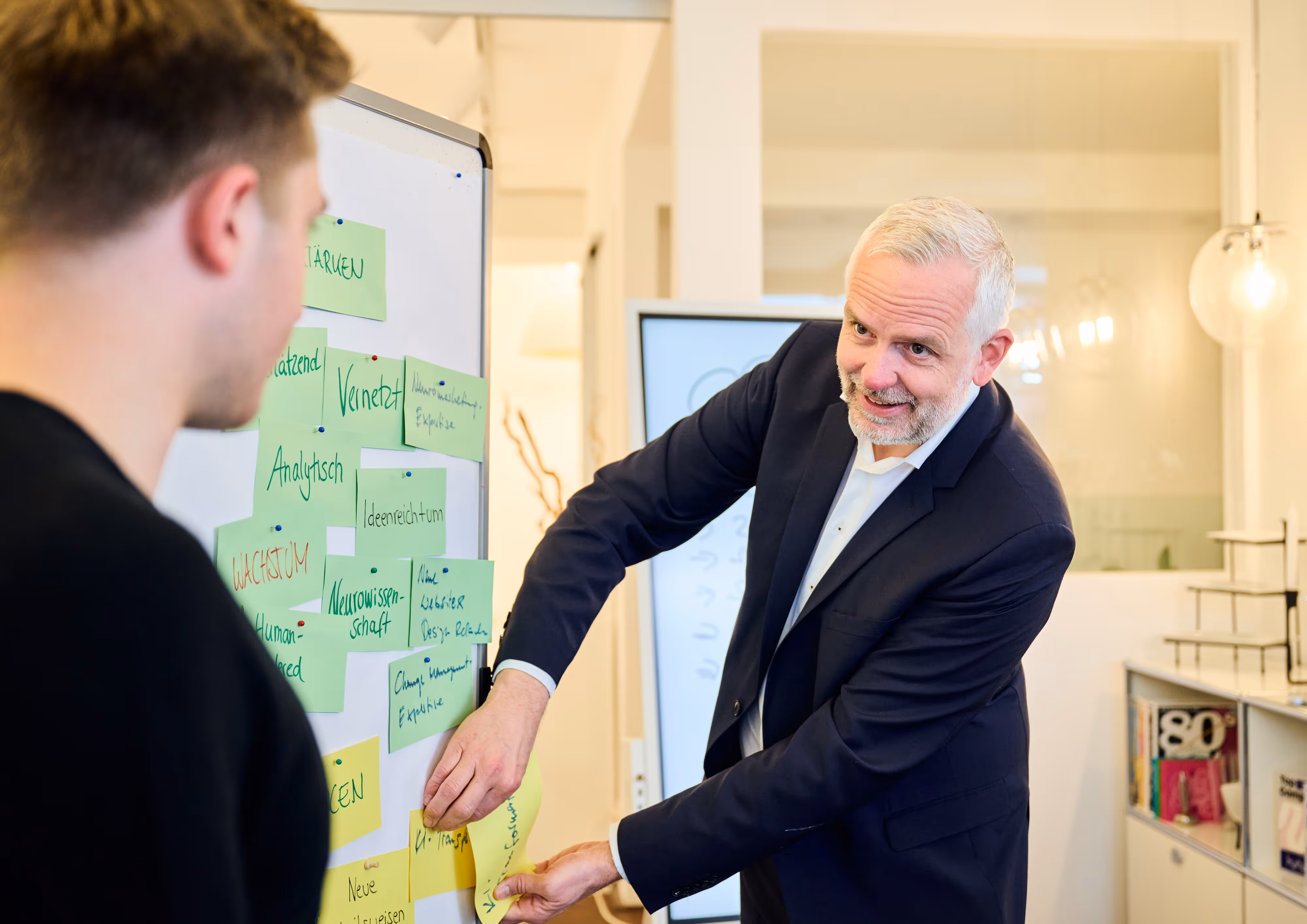zwei personen arbeiten an whiteboard