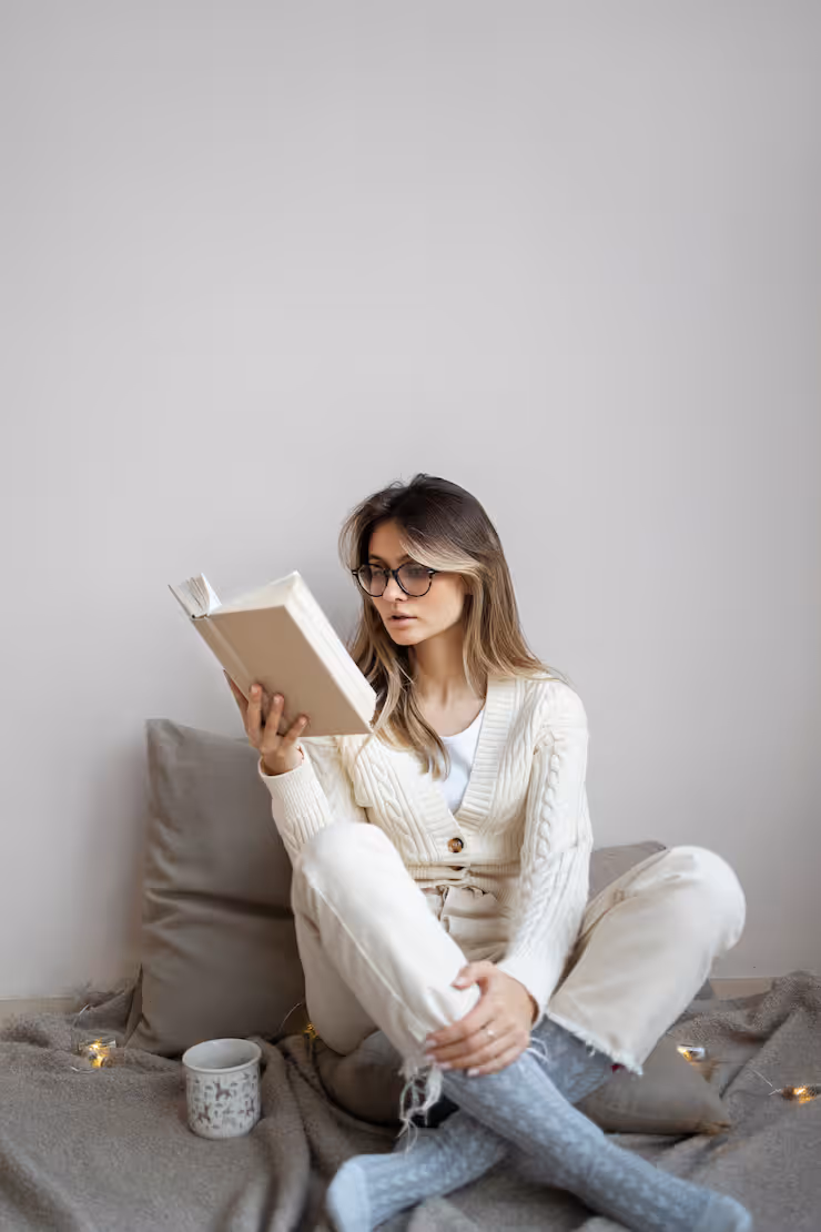 A woman reading a book on the couch