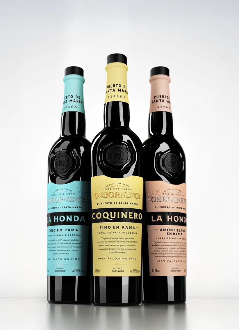 Tres botellas de vino fino de la marca Osborne, con etiquetas de colores azul, amarillo y rosa, sobre fondo blanco.