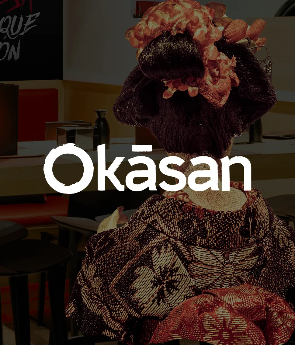Desde atrás, mujer con peinado tradicional y vestido de patrón japonés visto en interior de restaurante.