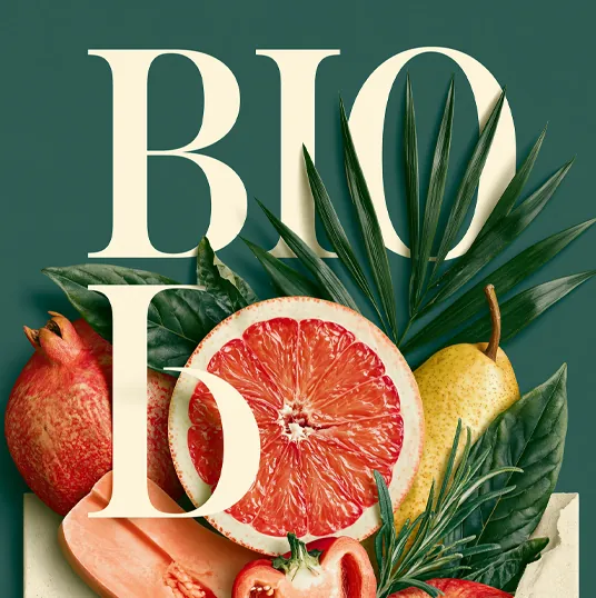 Frutas y hojas frescas delante del texto grande que dice BIO en fondo verde.