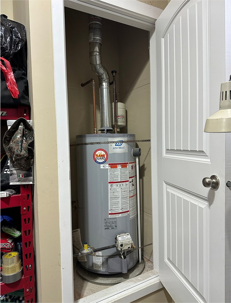 Residential water heater installed in a utility closet.