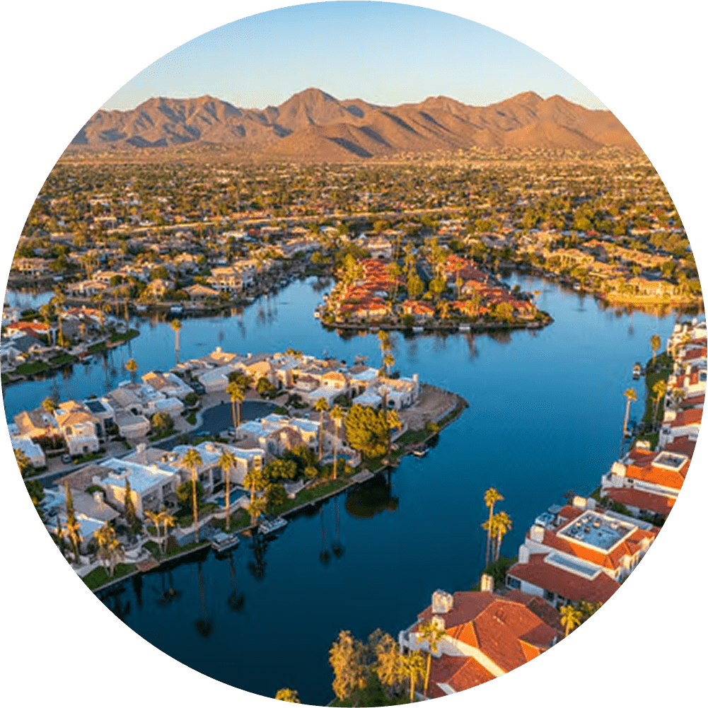 Aerial view of Scottsdale with a lake, homes, and desert mountains.