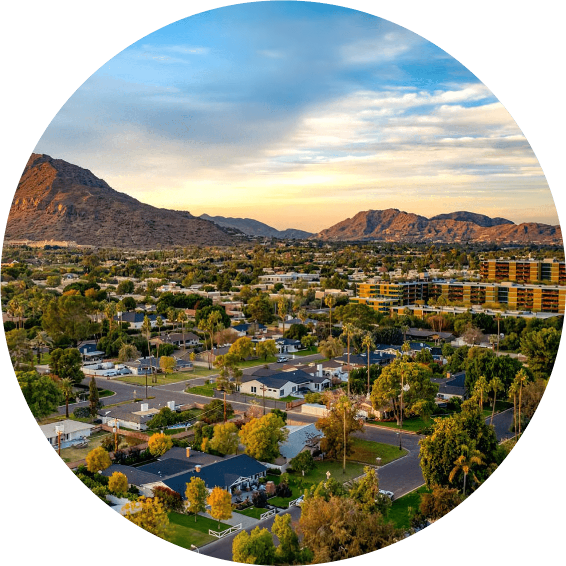 Scenic city view with a large bridge and surrounding mountains under a blue sky.