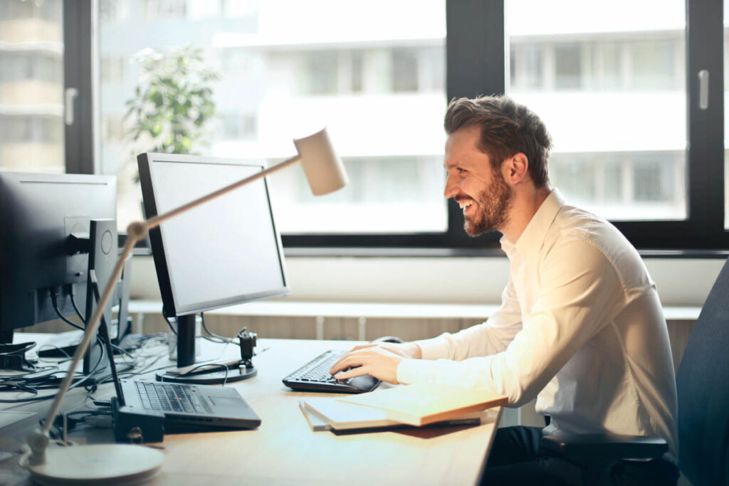 A data protection officer works at their computer, smiling