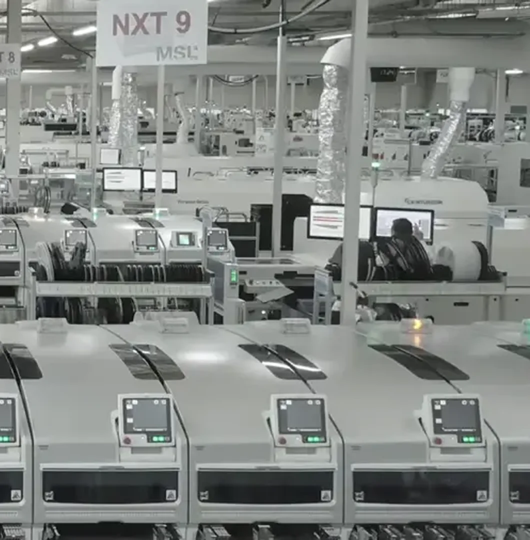 An industrial factory floor featuring automated electronics manufacturing machinery and assembly lines.