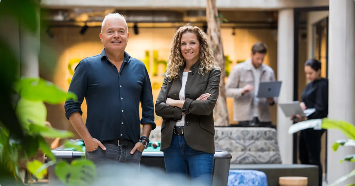 Maarten Franken and Annabelle Vultee stood side by side smiling at the camera in GoodHabitz office