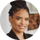 Frau mit Hochsteckfrisur, lächelnd, im schwarzen Blazer.