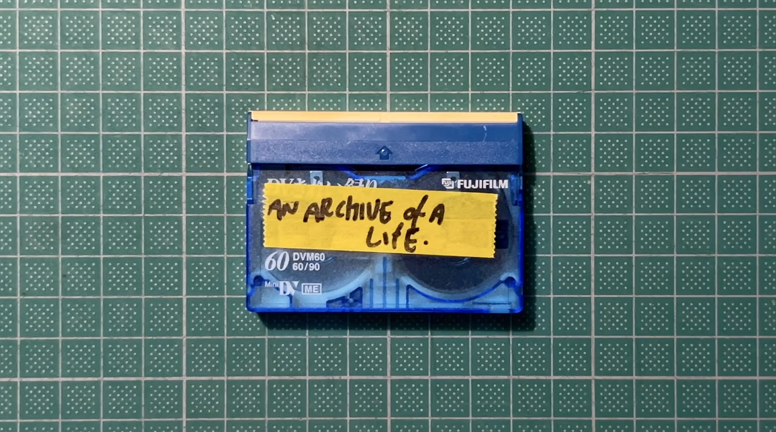 An old DVi Tape with a piece of tape on the front where the hand-written words "An Archive of a Life" are written.