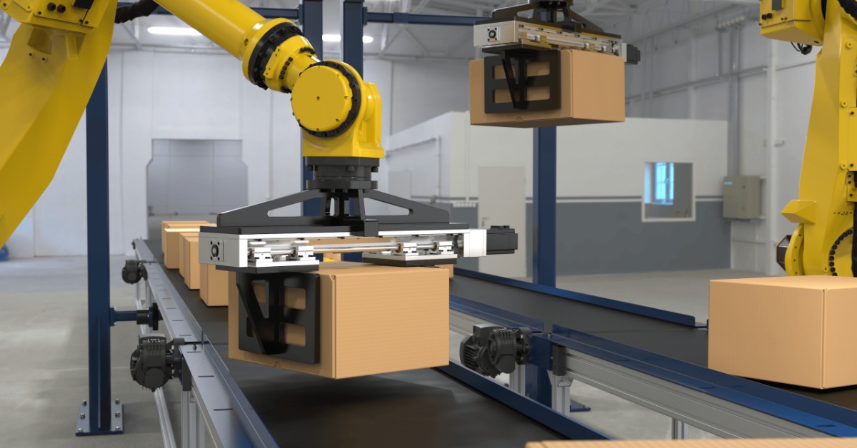 Yellow robotic arms lift cardboard boxes above conveyor belts as part of an automated material handling system.