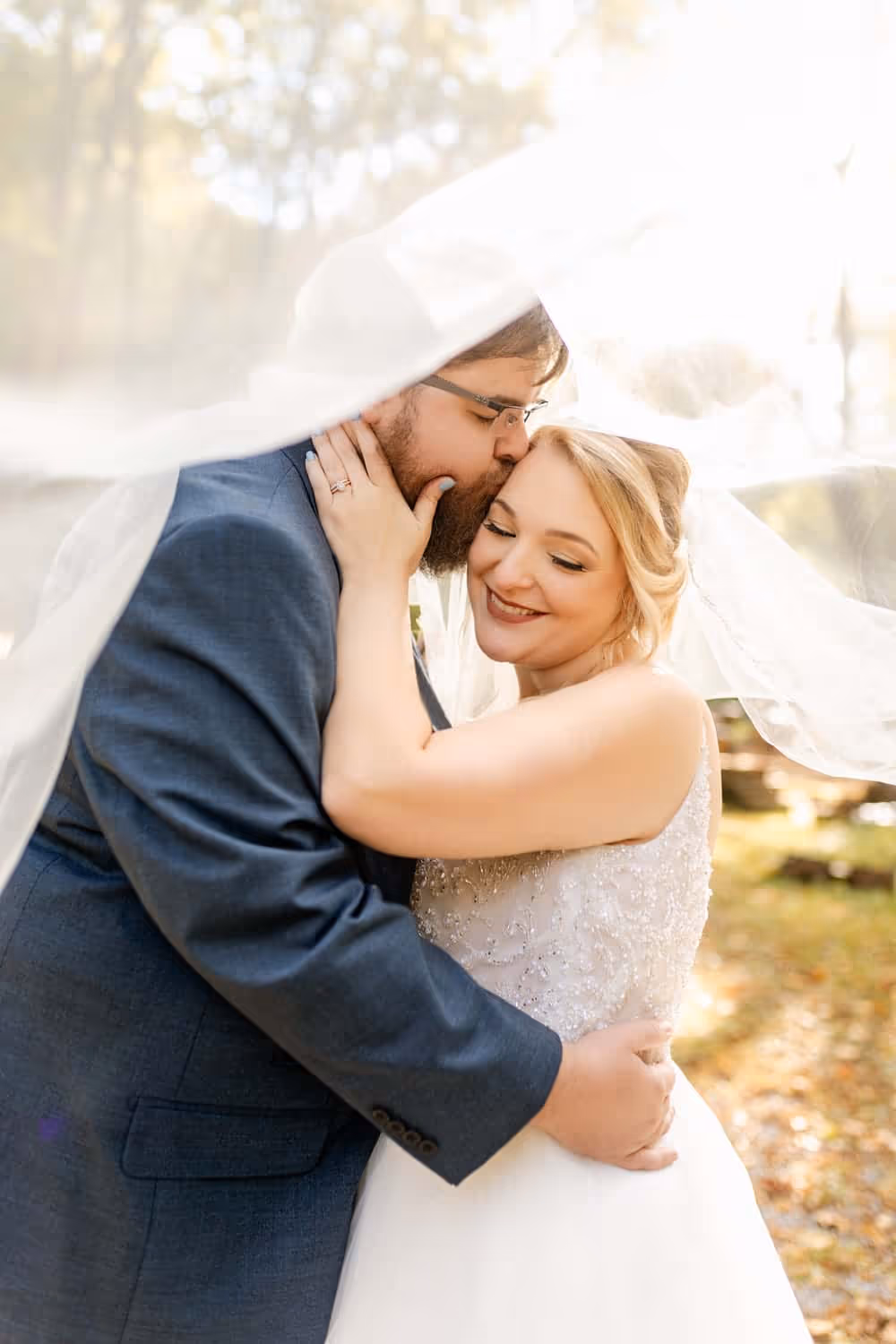A grrom kissing a bride on the cheeck at Elly's Mill in Gatlinburg, Tennessee.