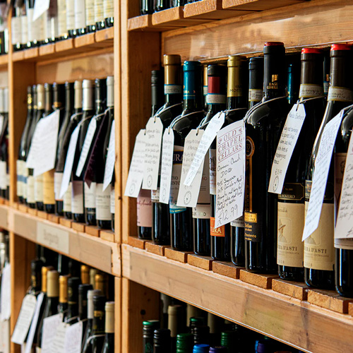 Assortment of wine bottles with price labels on display.
