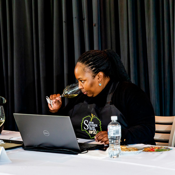 South African wine judge tasting white wine during the FNB Sauvignon Blanc South Africa 2025 competition.
