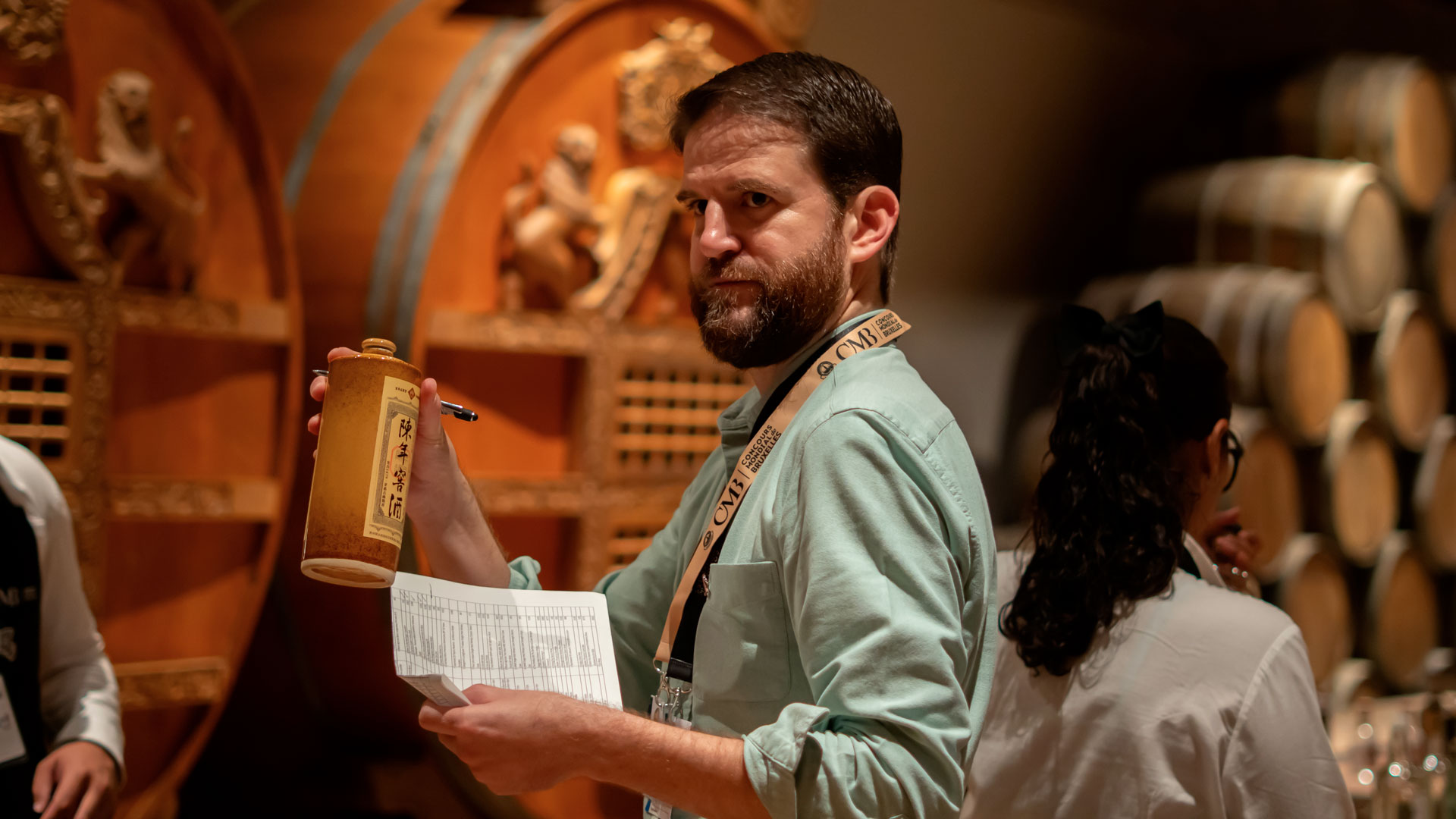 A member of the organizing team at the Spirits Selection by CMB 2025 in Tequila, Mexico, holding a spirits bottle while preparing the tasting sessions.