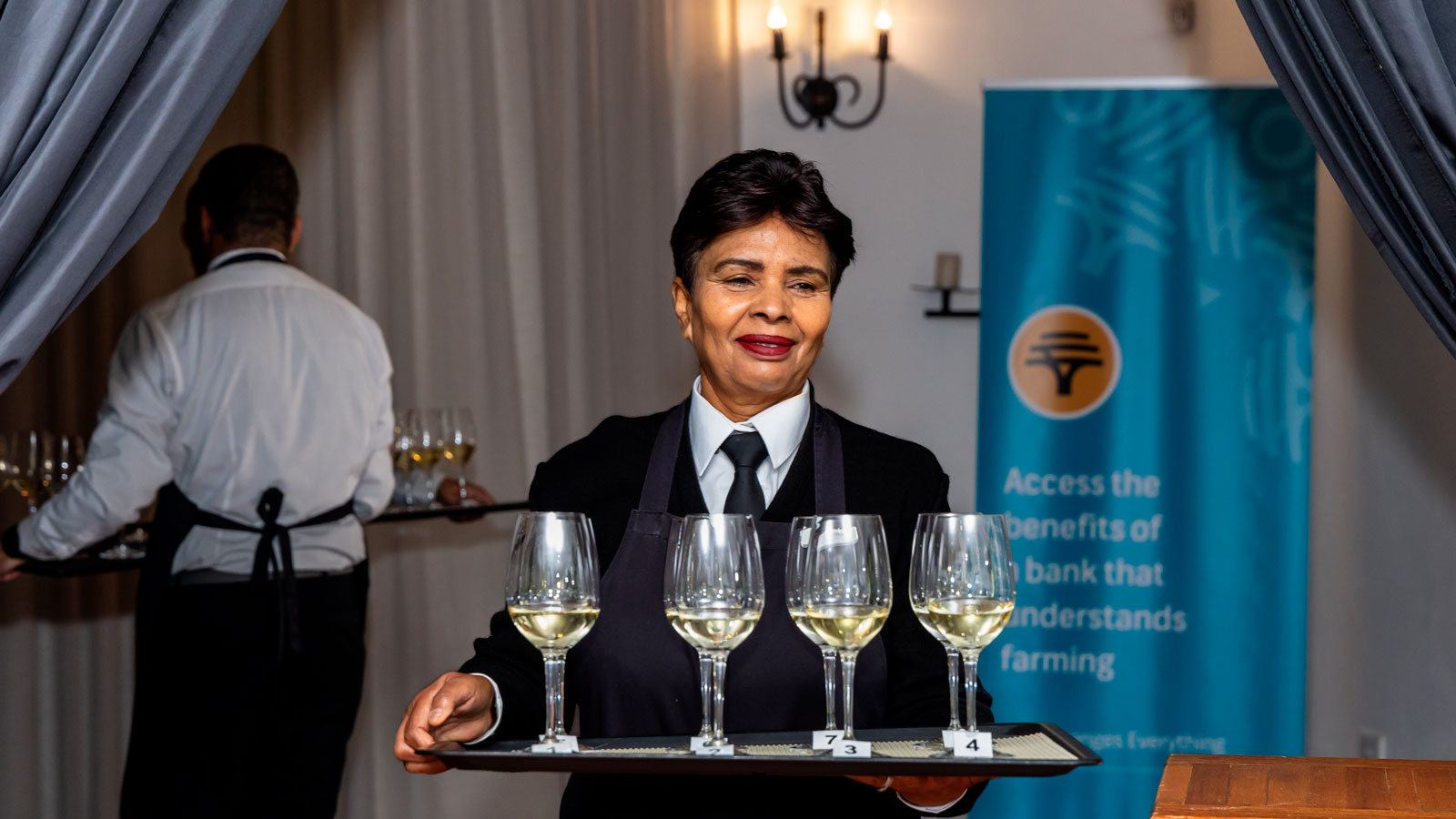 Wine service during the FNB South Africa Sauvignon Blanc Top 10 competition – a staff member bringing a tray of numbered Sauvignon Blanc samples to the judges.