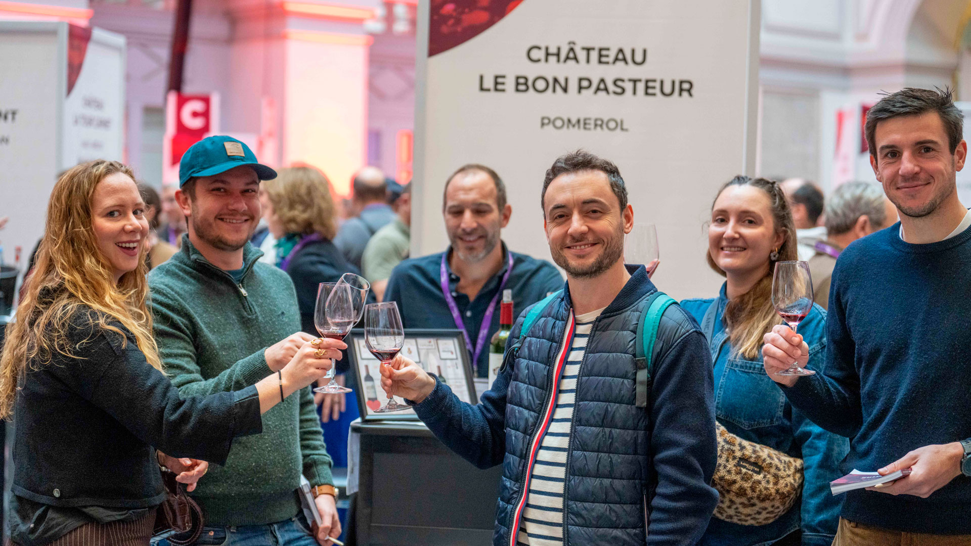 Des visiteurs profitent d’une dégustation de vins sur un stand de producteurs lors de Bordeaux Tasting 2025, partageant un moment convivial autour de verres de vin.