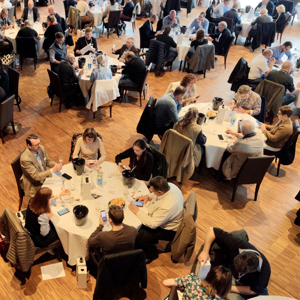 Overhead view of juries at the 2026 Concours National des Crémants tasting and scoring cuvées on smartphones with Tastee