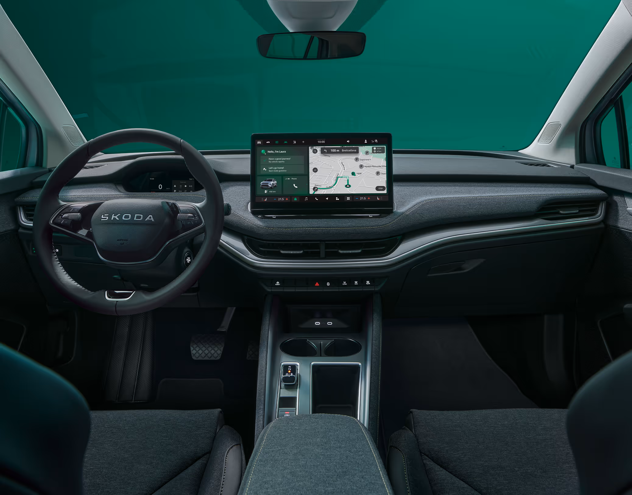 Blick über die Mittelarmlehne auf das Lenkrad, das Infotainmentsystem und das Armaturenbrett im Škoda Elroq in der Ausstattungslinie “Loft”.