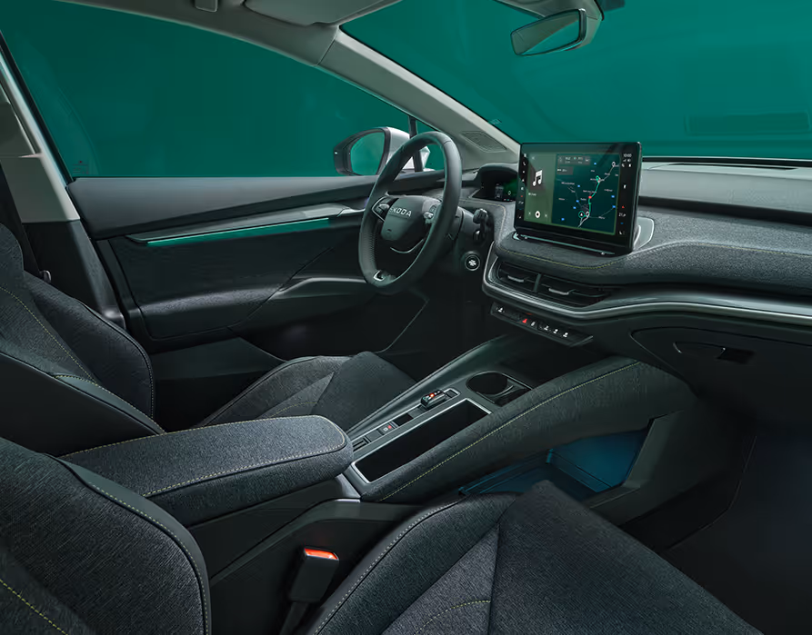 Beifahrer-Perspektive im Innenraum des Škoda Elroq in der Ausstattungslinie “Loft”. Der Blick fällt auf das Lenkrad, das Digital Cockpit und den zentralen Infotainment-Bildschirm.